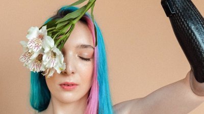 woman in black slip dress holding white flower upside down