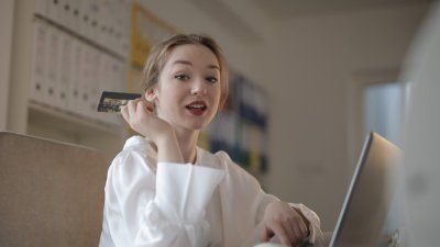 young woman with credit card paying online